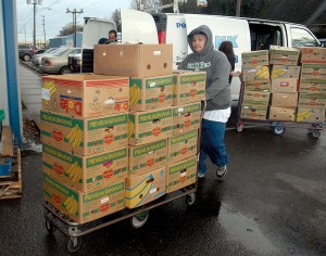 Port Angeles Food Bank volunteer Juan Figuero pushes a cart of food “rescued” from Port Angeles Safeway stores Tuesday at the food bank. Keith Thorpe/Peninsula Daily News