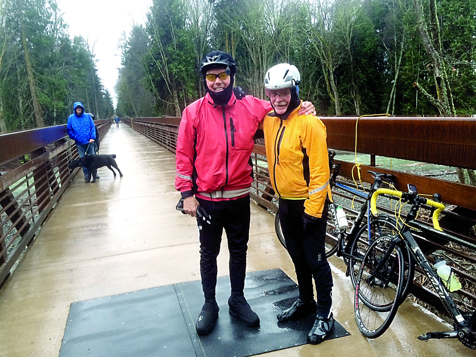 Garland Frankfurth and Bob Anundson were among the first bicyclists to cross the newly opened trestle Thursday. A bystander helped the two remove a fallen tree from the pathway.  Cheryl Garland