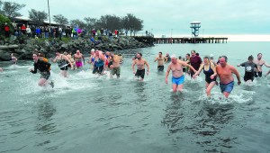 Polar bear dippers rush back out of the chilly waters of Port Angeles Harbor during the 2013 New Year's Day plunge at Hollywood Beach. — Keith Thorpe/Peninsula Daily News