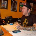 Professional tattoo artist Keith Dulin discusses tattoo design concepts with a client during the official opening of his business, Black Reign Tattoo, on Nov. 25 in Sequim. (Erin Hawkins/Olympic Peninsula News Group)