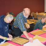 Gail Jangaard, Al Lathum and Michael Bradel make organic dog biscuits at the Gatheringplace in Port Townsend. (Mark Krulish/for Peninsula Daily News)