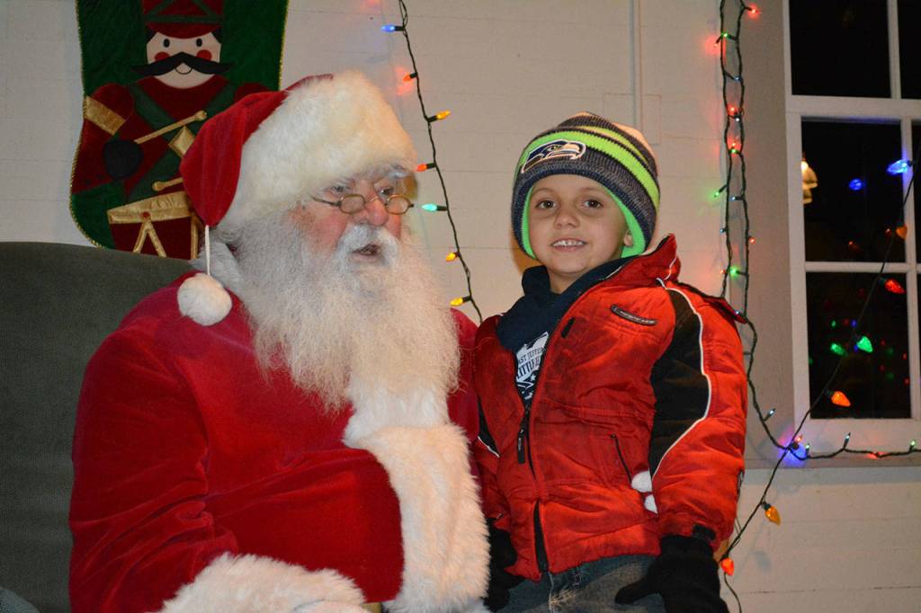 Owen Thetford, 6, meets with Santa Claus on Saturday in Port Townsend. (Mark Krulish/for Peninsula Daily News)