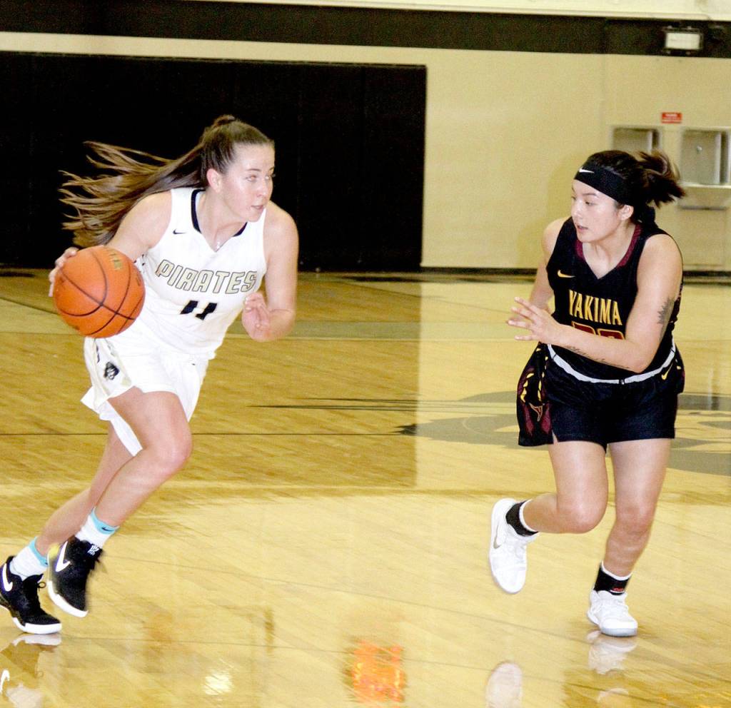 Peninsulas Ashlynn Clark (11) drives against a Yakima defender during Sundays game against the Yaks. The Pirates lost 68-57. (Dave Logan/for Peninsula Daily News)