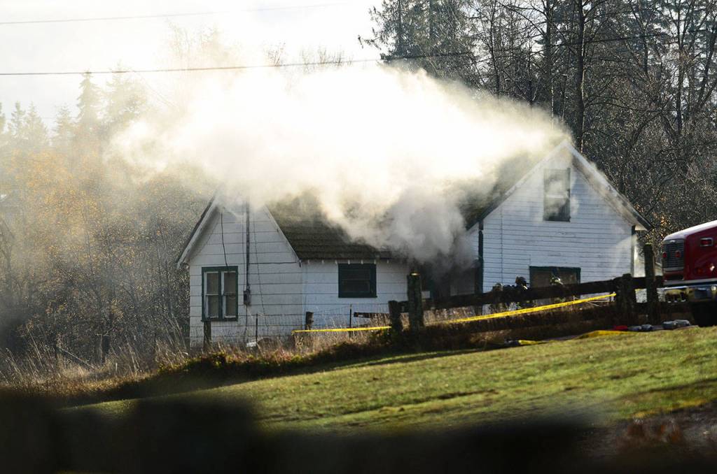 Smoke pours out of a home that firefighters set on fire for training in Port Angeles on Sunday. (Jesse Major/Peninsula Daily News)