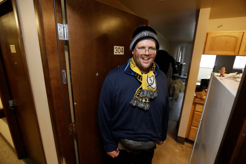 Garrick Heller stands in the doorway of his studio apartment in Everett on Nov. 1. Heller, who was diagnosed with paranoid schizophrenia, and has lived on the streets, in shelters and eventually in a locked psychiatric facility, has been able to transition into housing and mental health counseling run by Compass Health, a Snohomish County behavioral health provider. (Ted S. Warren/The Associated Press)