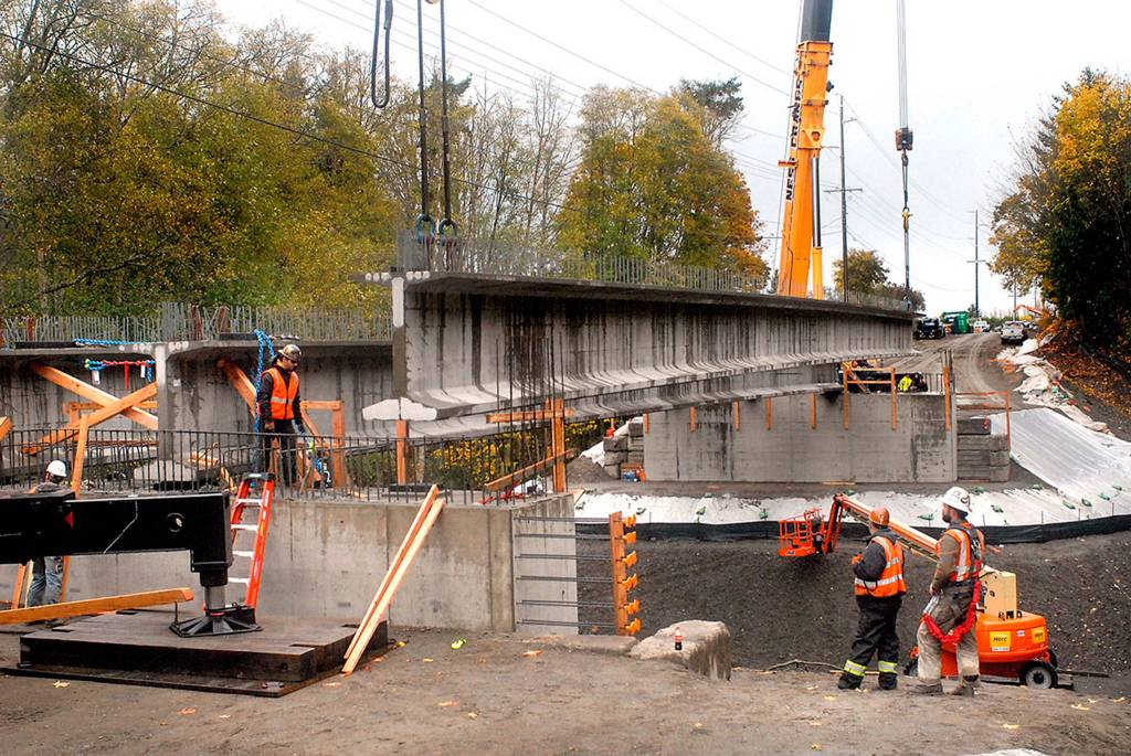 <strong>Keith Thorpe</strong>/Peninsula Daily News                                A crew from Ness Cranes of Seattle hoists the last of four 148-foot reinforced concrete beams into place in early November for what will become the new Old Olympic Highway bridge spanning McDonald Creek west of Sequim. The new bridge replaces a narrower 1957-vintage span.                                 that was considered too narrow and inadequate for modern traffic.