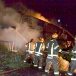 Capt. Chris Turner with Clallam County Fire District 3 leads Explorer Scouts with Post 1003 in fighting a house fire Monday night on 3 Crabs Road. (Matthew Nash/Olympic Peninsula News Group)