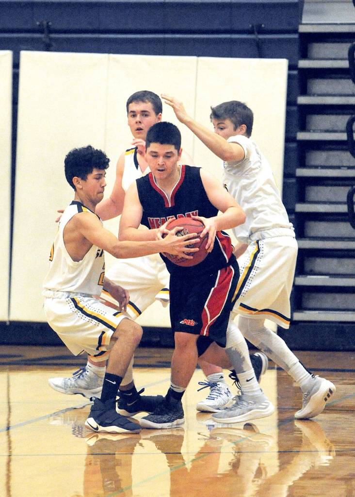 Lonnie Archibald/for Peninsula Daily News Neah Bay ran into a tough Forks defense during a 68-29 loss to the Spartans on Wednesday night. From left, Forks Tony Flores, Scott Archibald and Joseph Reaume trap Neah Bays Captain Claplanhoo (center).