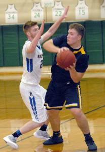Keith Thorpe/Peninsula Daily News Forks Cort Prose looks to pass around the defense of Rochesters Keegan Goldrick during Saturday nights consolation round of the Port Angeles Holiday Basketball Tournament at Port Angeles High School.