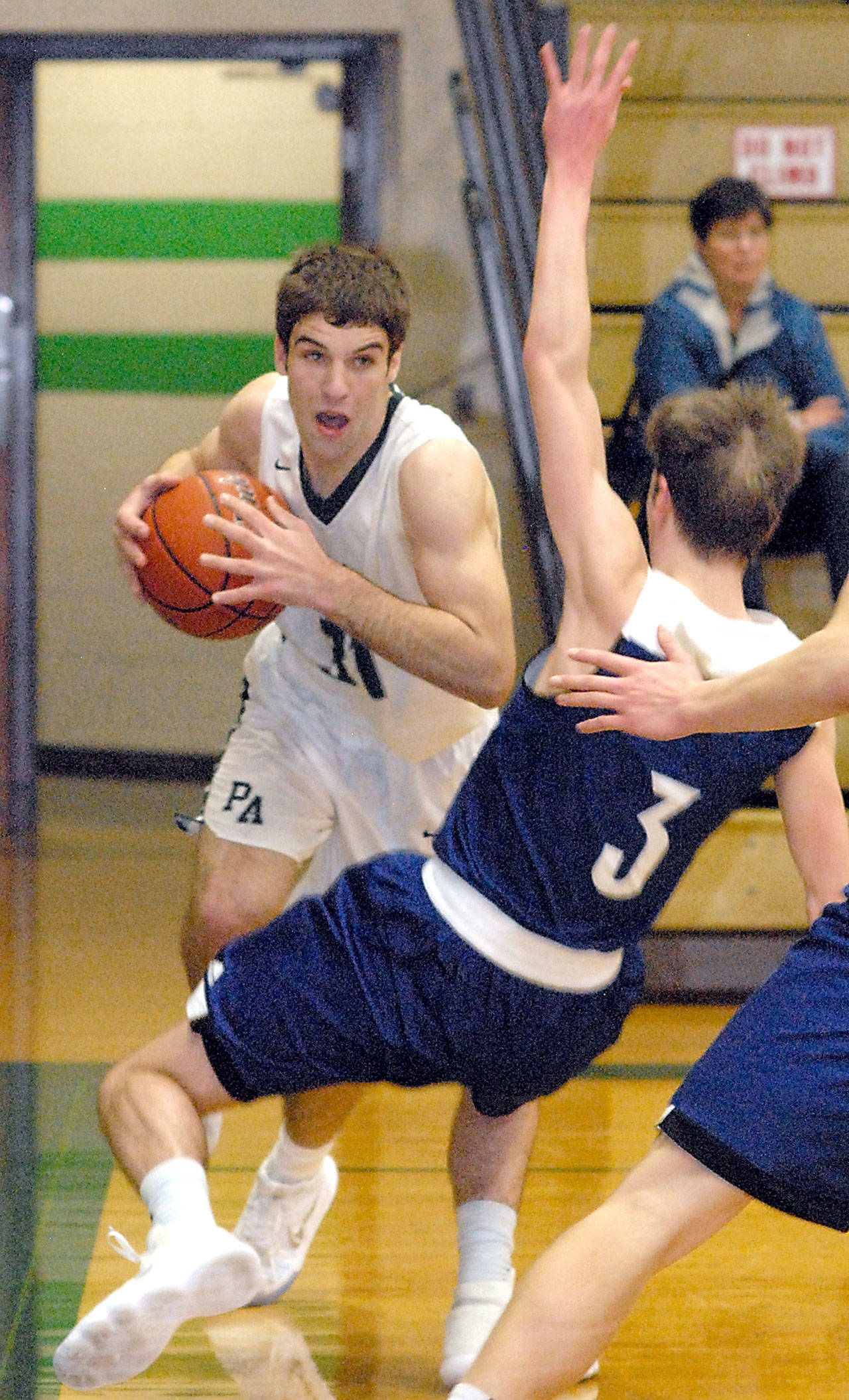 Keith Thorpe/Peninsula Daily News Port Angeles Garrett Edwards, left, drives to the lane through Sedro-Woolleys Cade Isakson during Saturday nighs championship round of the Port Angeles Holiday Basketball Tournament.
