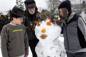 Oscar, Michael and Ruth Levine of Walker Street, Port Townsend, created a snowman for their neighbors as a Christmas surprise.They used volunteer plant material, repurposed Halloween mini-pumpkins, a squash and bread for lips. The project started out as a snowball fight and grew from there. (Jeannie McMacken for Peninsula Daily News).