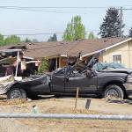A crushed truck and a house knocked off its foundation sit as part of the aftermath of a rampage by a man driving a bulldozer on Friday, May 10, 2013, in Port Angeles. At least three houses were destroyed and numerous smaller structures and vehicles were damaged in the rampage, which also cut electrical power to the area when a power pole was toppled. (Keith Thorpe/Peninsula Daily News)