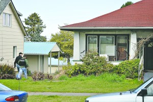 Police walk around side of house