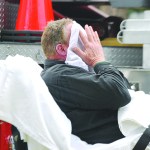 The unidentified heating company worker holds a wet towel to his face after receiving minor burns. He was taken to Olympic Medical Center in Port Angeles. Photo by Jeff Chew/Peninsula Daily News. Jeff Chew/Peninsula Daily News