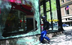 A protester smashes a window at a Wells Fargo branch during a May Day rally today in downtown Seattle. Mayor Mike McGinn says hes making an emergency declaration allowing police to confiscate items that can be used as weapons following violent May Day protests that left storefronts and car windows shattered. -- Photo by Joshua Trujillo/Seattlepi.com via The Associated Press