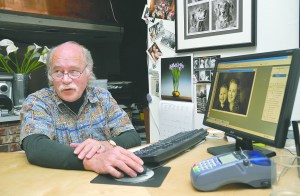 Ernst-Ulrich Schafer shows a photograph to one of his clients while working in his Port Angeles studio.  -- Photo by Chris Tucker/Peninsula Profile