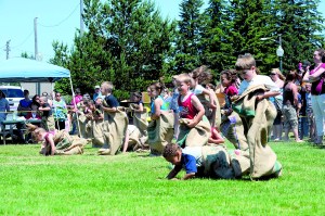 Children hop across the grass in Tillicum Park in Forks during the gunny sack races in the Old-Fashioned Fourth in 2011. Lonnie Archibald/for Peninsula Daily News