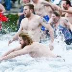 Swimmers dive into the Strait of Juan de Fuca during the annual Polar Bear Dip at Hollywood Beach in Port Angeles on Monday. (Jesse Major/Peninsula Daily News)