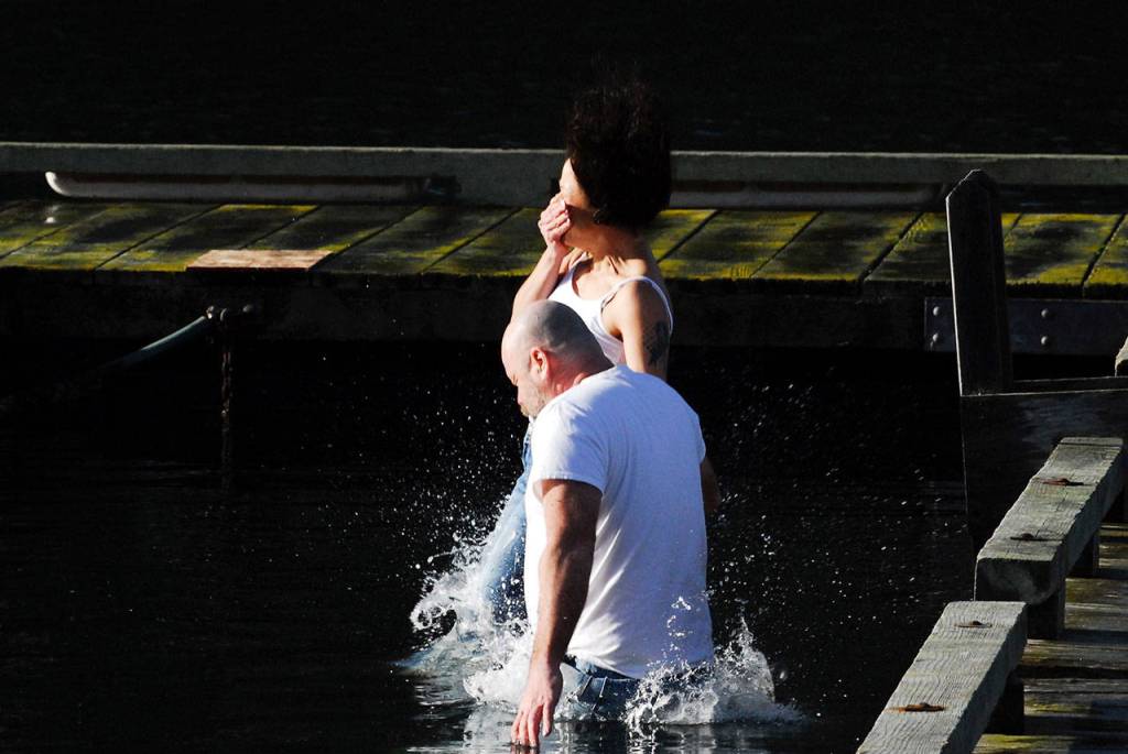 Angie Shires and Lue Bland take the polar bear plunge fully clothed Monday in Nordland. (Jeannie McMacken/for Peninsula Daily News)
