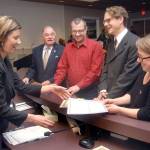 Port Angeles City Clerk Jennifer Veneklasen, left, collects signed paperwork from new City Council members, from center left, Jim Moran, Mike French, Lindsey Schromen-Wawrin and Kate Dexter after the four were sworn in to their positions during a special ceremony Tuesday at Port Angeles City Hall. The new members later joined incumbents Cherie Kidd, Sissi Bruch and Michael Merideth for the first council meeting of 2018. (Keith Thorpe/Peninsula Daily News)