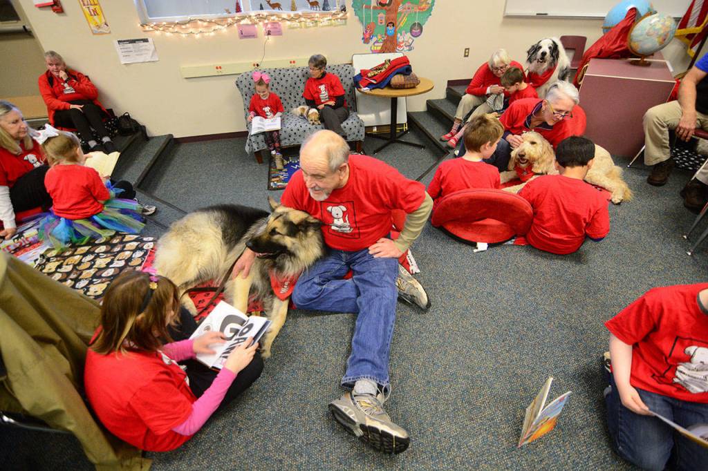 Students read to dogs at Chimacum Creek Primary School on Friday as part of the Read to Rover program. (Jesse Major/Peninsula Daily News)