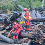 Search and rescue workers pause on an Elwha River log jam on Monday. (Jay Cline/Clallam County Fire District No. 2)