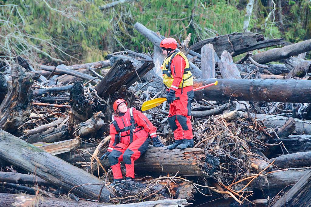 Search and rescue workers pause on an Elwha River log jam on Monday. (Jay Cline/Clallam County Fire District No. 2)
