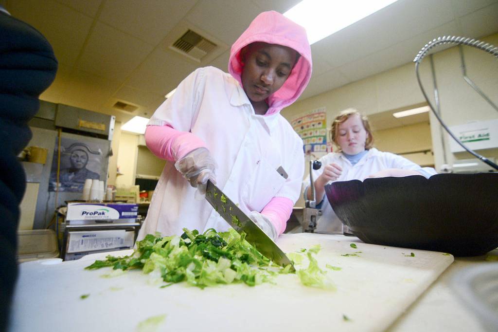 Allanah Carron, an 11th-grade student at Quilcene School, cuts fresh vegetables for the schools salad bar Thursday. (Jesse Major/Peninsula Daily News)