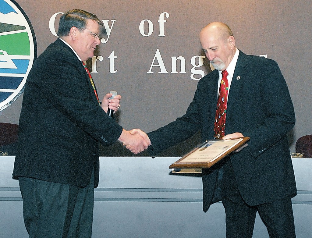 Port Angeles Mayor Dan Di Guilio, left, congratulates outgoing City Council Member and Deputy Mayor Don Perry a City Council meeting. Perry was honored for his service as council member and for serving two years as deputy mayor. (Keith Thorpe/Peninsula Daily News)