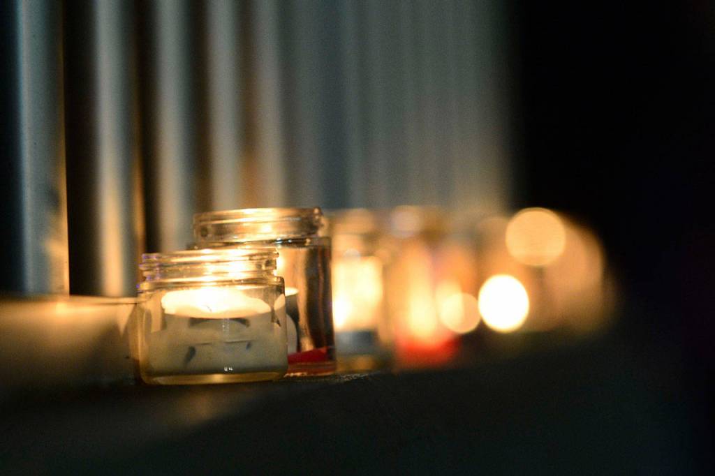 Candles flicker along the rail of the Valley Creek Eighth Street bridge in Port Angeles on Wednesday. (Jesse Major/Peninsula Daily News)