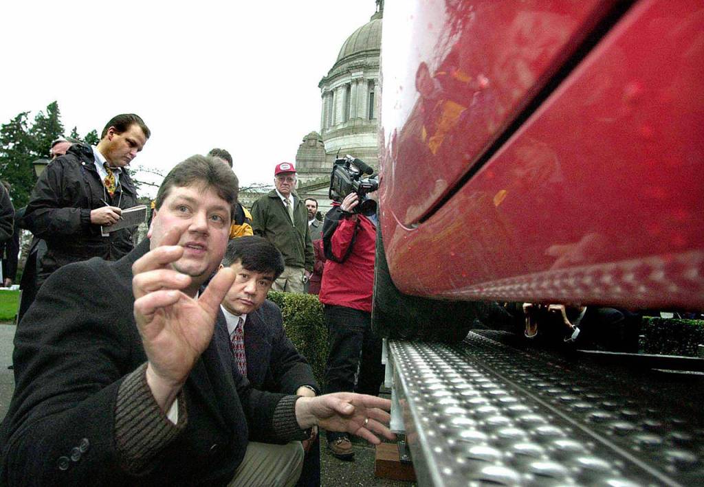 Karl J. Lamb, front, demonstrates a magnetic levitation system for Washington Gov. Gary Locke near the Capitol in Olympia on Feb. 6, 2002. (AP Photo/The Olympian, Steve Bloom)