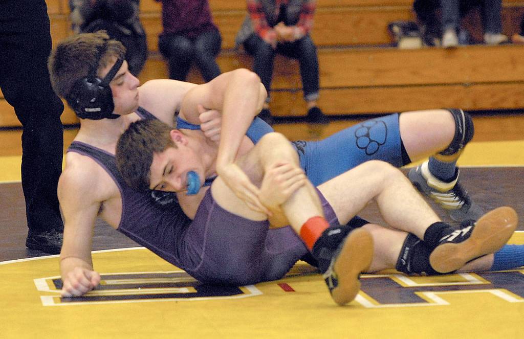 Keith Thorpe/Peninsula Daily News Sequims Garrett Harris, left, takes on North Masons Jimmy Burch in the 128 lb. weight class during Saturdays tournament at Sequim High School.