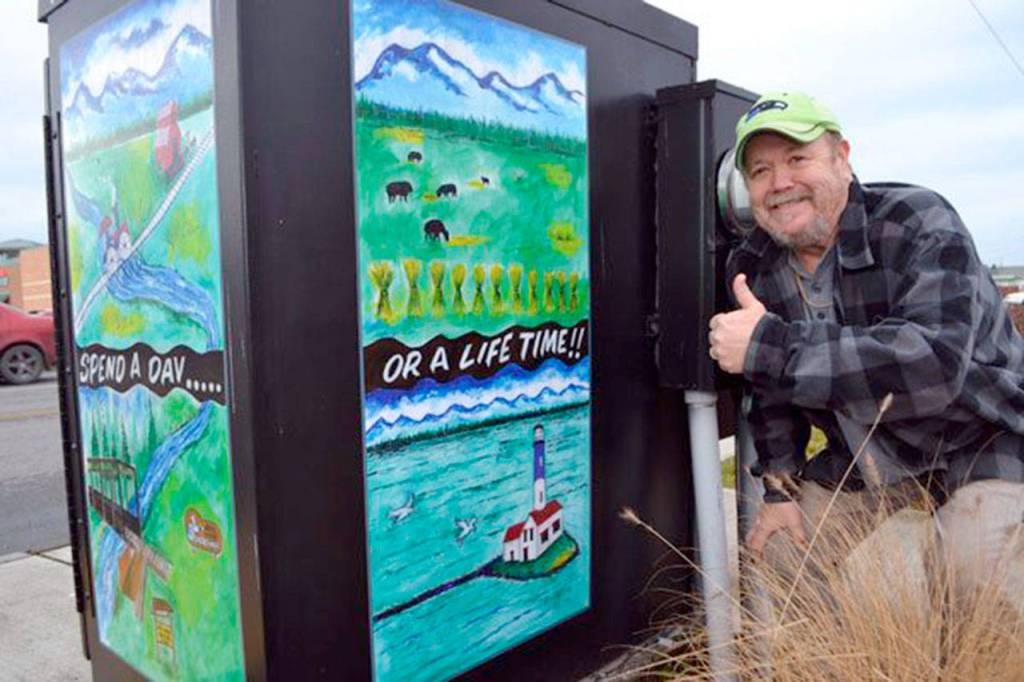 Gary Robertson is pictured in 2014 with his three-piece watercolor art wrapped in vinyl around a utility box at the corner of Washington Street and Fifth Avenue on the northeast corner in Sequim. He is a new member of The Landing Artists Studio.