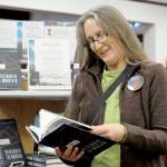 Cheryl Wallace of Port Townsend peruses a copy of Leif Whittakers My Old Man and the Mountain, this years Port Townsend Community Read selection, from the library display. Wallace said she heard Whittaker make a presentation in the past and believes the book will be as interesting and compelling as his talk. (Jeannie McMacken/for Peninsula Daily News)