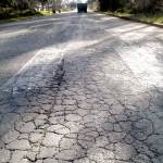 A cracked road surface greets motorists on West 10th Street in Port Angeles. The street is being considered for resurfacing by the city. (Keith Thorpe/Peninsula Daily News)