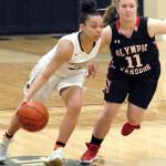 Peninsulas Tiffany Smith, left, drives downcourt while guarded by Olympics Shanya Nisbet, a Chimacum graduate, Wednesday in Port Angeles.                                Keith Thorpe/Peninsula Daily News