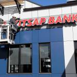 Brian Walters from Hanson Signs in Bremerton puts the finishing touches on the newly remodeled Kitsap Bank branch in Port Townsend. The building, which opened Monday, features green design, solar roof panels and recycled building products. (Jeannie McMacken/Peninsula Daily News)