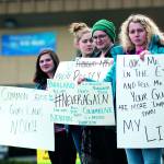 Port Angeles High School students, from left, Gillian Elofson, 17, Charlotte Hertel, 16, Darbey Martin, 17, and Emily Menshew, 17, demonstrate outside a gun and knife show at the Port Angeles Masonic Temple calling for gun control. (Jesse Major/Peninsula Daily News)