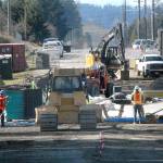Construction crews work Tuesday to build the approaches to a new bridge on Old Olympic Highway over McDonald Creek east of Port Angeles. (Keith Thorpe/Peninsula Daily News)