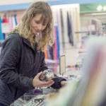 Michele Adolphsen, who owns Bay Variety in Port Angeles, organizes merchandise Tuesday. (Jesse Major/Peninsula Daily News)