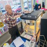 Rudy Hiener wipes off the popcorn-maker at Bay Variety in Port Angeles on Tuesday. (Jesse Major/Peninsula Daily News)