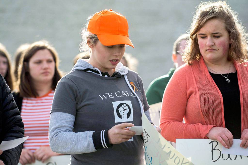 Port Angeles High School Senior Emily Menshew, 17, reads the name of one of the 17 people killed in a Florida high school last month. (Jesse Major/Peninsula Daily News)