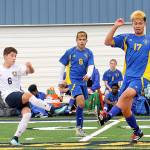 Forks Oscar Gonzalez (6) kicks past Bremerton defenders Luis Clemen (8) and Alex Mejia (17) Saturday on the Spartan turf where Forks defeated the Knights 4 to 0. (Lonnie Archibald/for Peninsula Daily News)