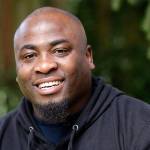 Orlando Wright smiles as he poses for a photo at his home in Kent. Wright, who was released from a Washington state prison a few months early due to a software glitch, is suing the Department of Corrections, saying his re-arrest three years later to serve the remaining time was illegal and upended the life he had painstakingly rebuilt. (Elaine Thompson/The Associated Press)