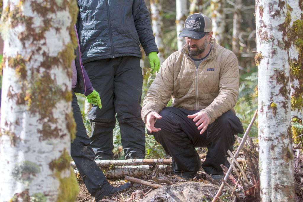 Mark Elbroch, right, lead scientist in Pantheras puma program, examines an elk killed by a cougar that Lower Elwha Klallam Tribe researchers are tracking. (Jesse Major/Peninsula Daily News)