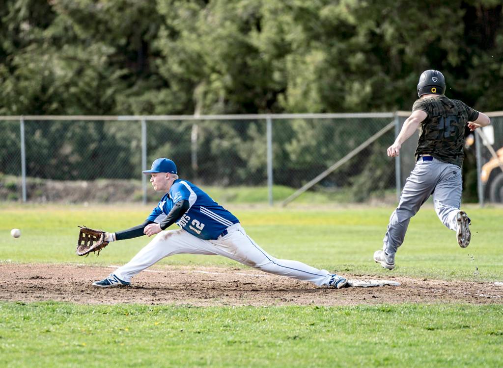 <strong>Steve Mullensky</strong>/for Peninsula Daily News                                Quilcenes Jake Oen is thrown out at first base in the first game of a Friday double-header against the Chimacum Cowboys in Quilcene. Making the stretch is the Cowboys Cody Clark.