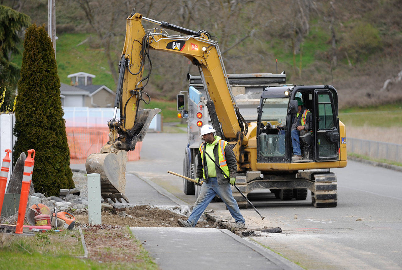 Workers with InterWest Construction Inc. work on installing new sidewalk stretches and ADA-compliant curbs recently. Funding for the project comes from Sequims Transportation Benefit District. (Michael Dashiell/Olympic Peninsula News Group)