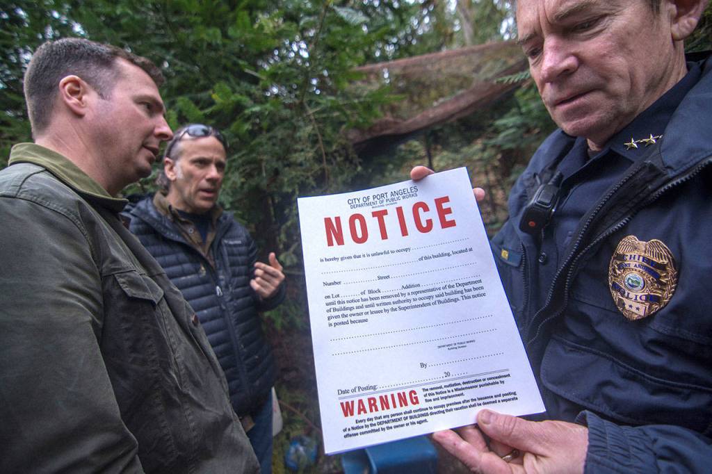 Port Angeles Police Chief Brian Smith holds a notice warning against trespassing on city property Wednesday. (Jesse Major/Peninsula Daily News)