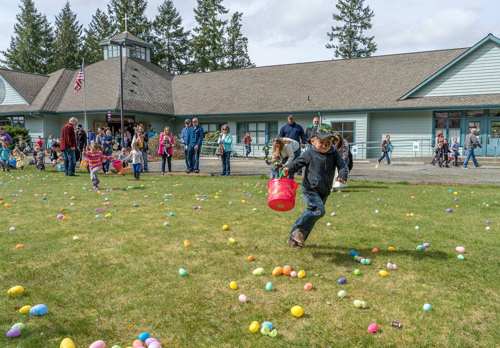 Connor Ryan, 3, from Chimacum, dashes for a group of eggs that hold the promise of lots of chocolate candy during the 13th Easter Egg Hunt at the Lutheran Church of the Redeemer in Port Hadlock on Saturday. (Steve Mullensky/for Peninsula Daily News)