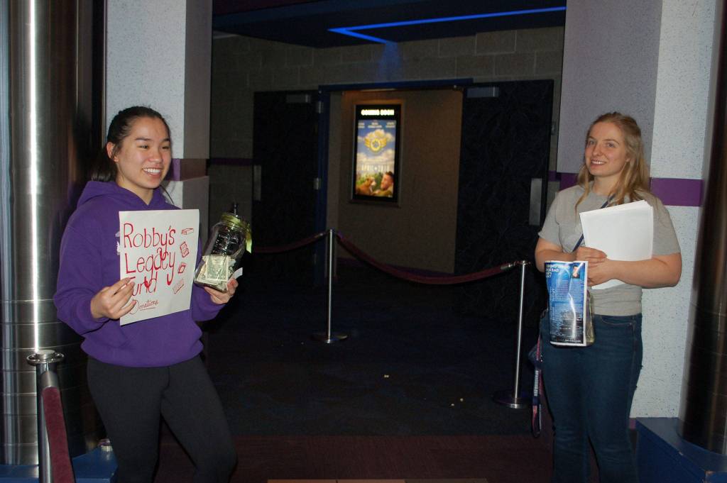 Sequim High School sophomore Lesae Pfeffer, left, and senior class president Anabelle Armstrong fundraise in Robby Streetts name at Deer Park Cinema before the film Ready Player One. They aim to raise money to to help the Sequim High library purchase new furniture and help students indulge in one of Robbys favorite activities, reading. (Erin Hawkins/Olympic Peninsula News Group)